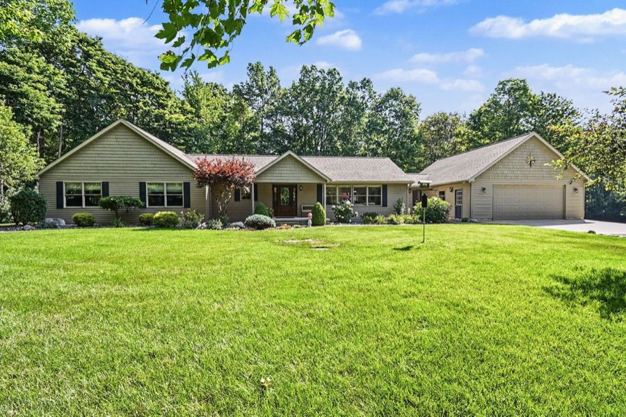 Daylight front exterior of the ranch home with its attached garage and front lawn
