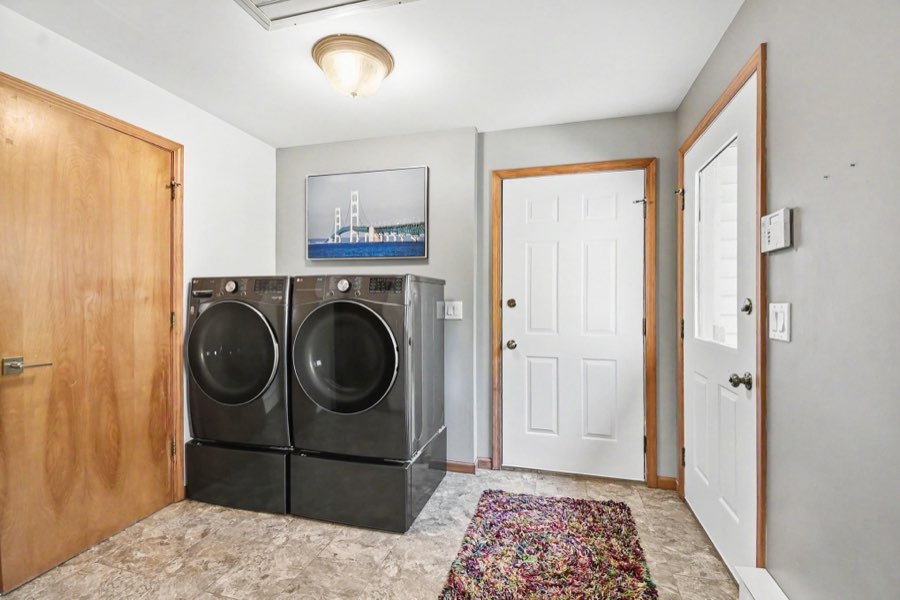 Main-floor laundry room with storage cabinetry and utility sink