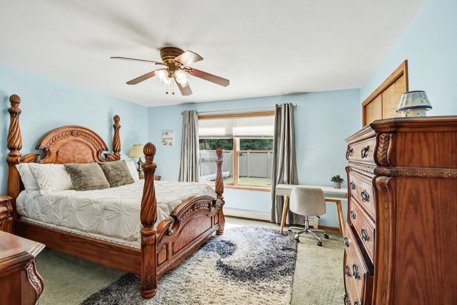 Secondary bedroom with two windows and carpeted floor