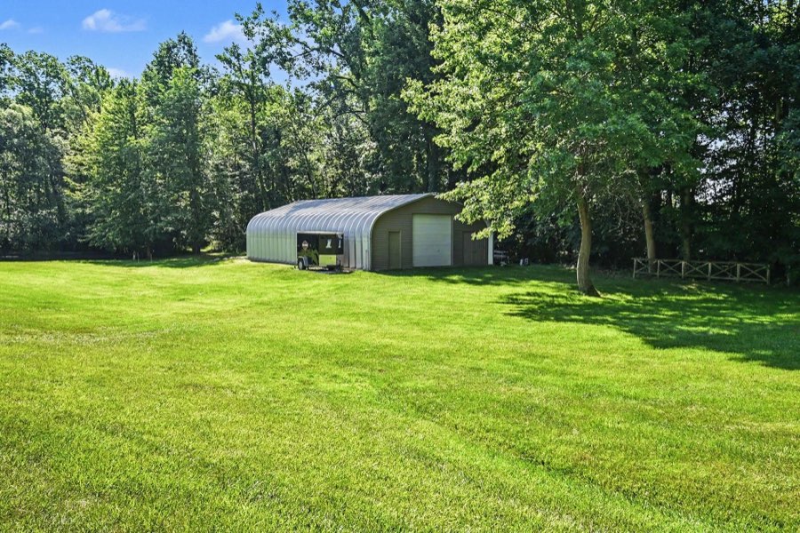 Exterior of the 1,581-square-foot Quonset steel outbuilding beside an open lawn