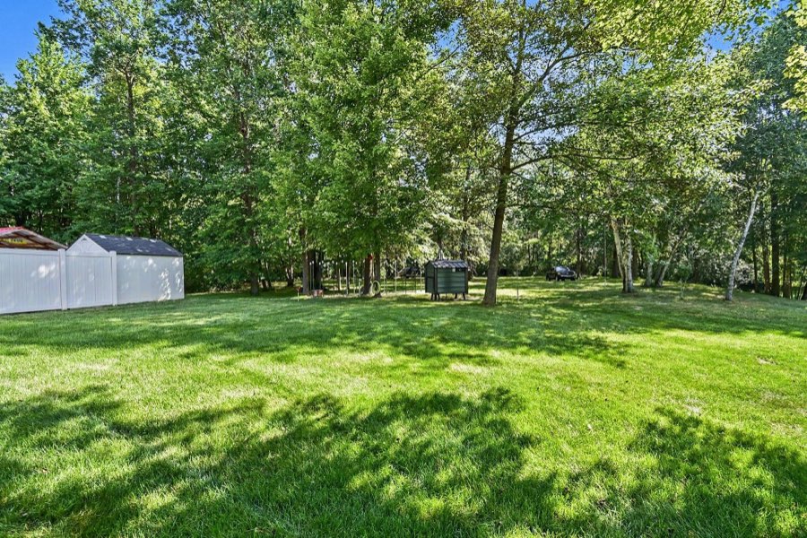 Outdoor wood stove and pool-area support buildings beyond the privacy fence